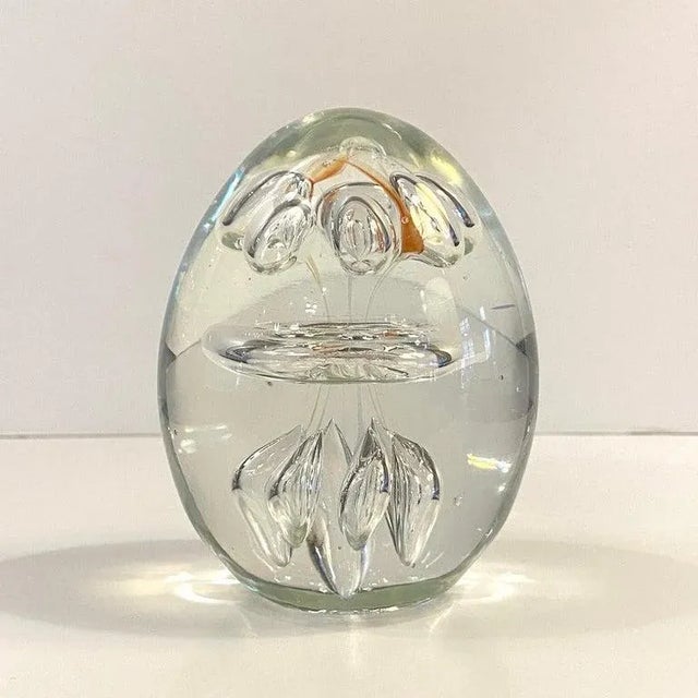 Hand-blown, clear, oblong, art glass paperweight features a clear hand-blown center ring with several controlled bubbles...