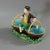 Minton Majolica dish which features a young male vintager, sat between two baskets. Colouration: brown, green, yellow, are...
