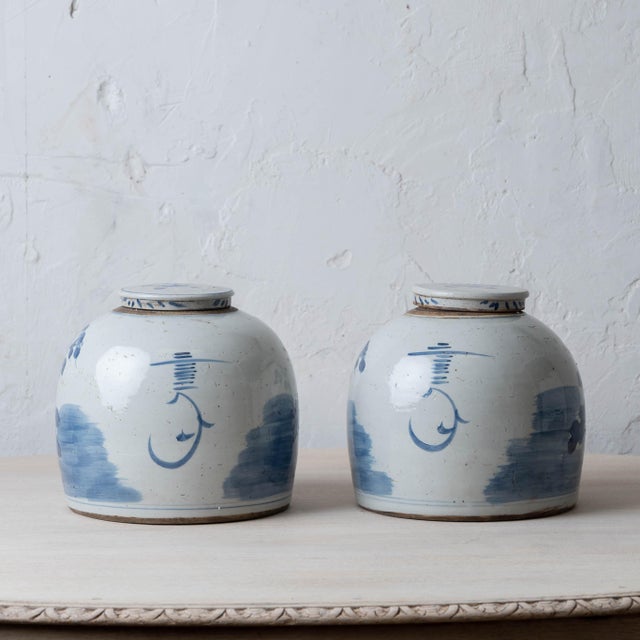 A pair of Chinese blue and white porcelain ginger jars, each of ovoid form with a domed lid, hand-painted in underglaze...