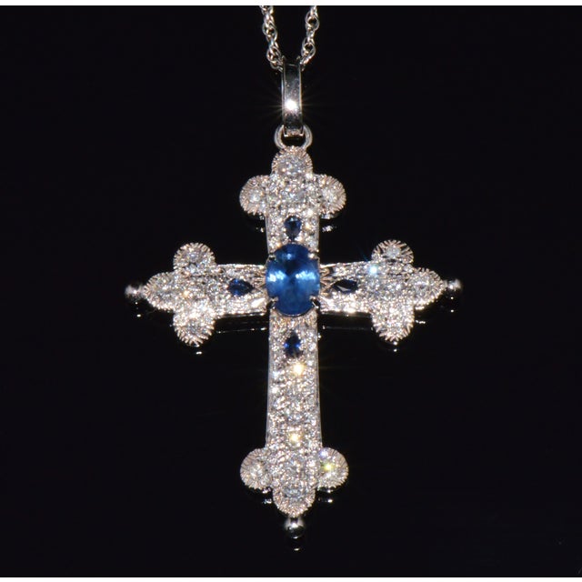 This is a gorgeous natural sapphire and diamond cross pendant crafted in solid 18K white gold. This luxurious pendant...