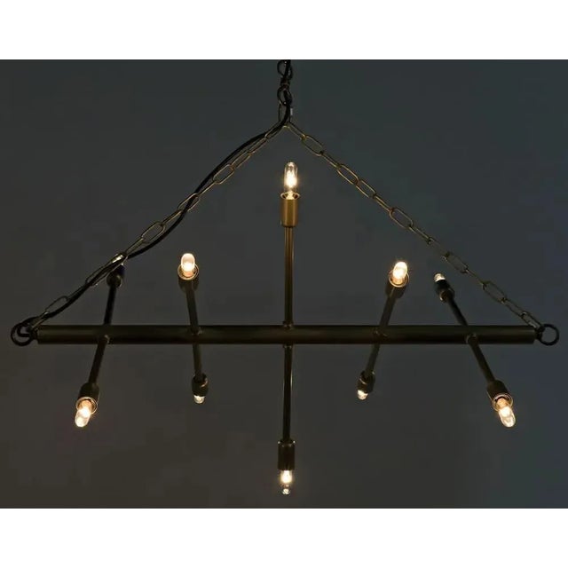 Modern, minimalistic, and sculptural, this unique chandelier's metal appendages are tipped with 12 small bulbs. Blurring...