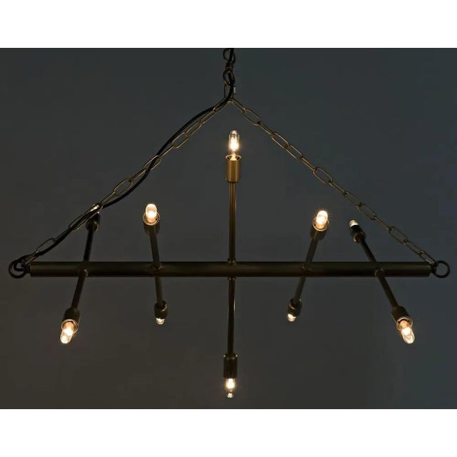 Modern, minimalistic, and sculptural, this unique chandelier's metal appendages are tipped with 12 small bulbs. Blurring...