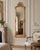 A dramatic 1970s French Baroque Rococo–style full-length floor mirror, designed with an ornate carved frame and a warm...