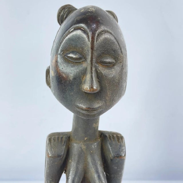 The Luba female figure is crafted as a veneration of feminine beauty and motherhood. Crafted from wood, the Luba female...