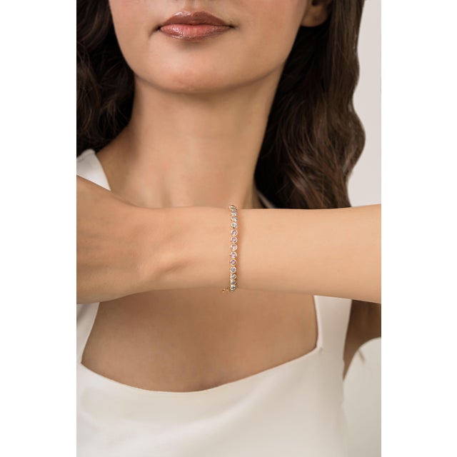 This tennis bracelet showcases 6.02 carats of round-cut natural multi-sapphires set in 14K yellow gold. The 42 sapphires...
