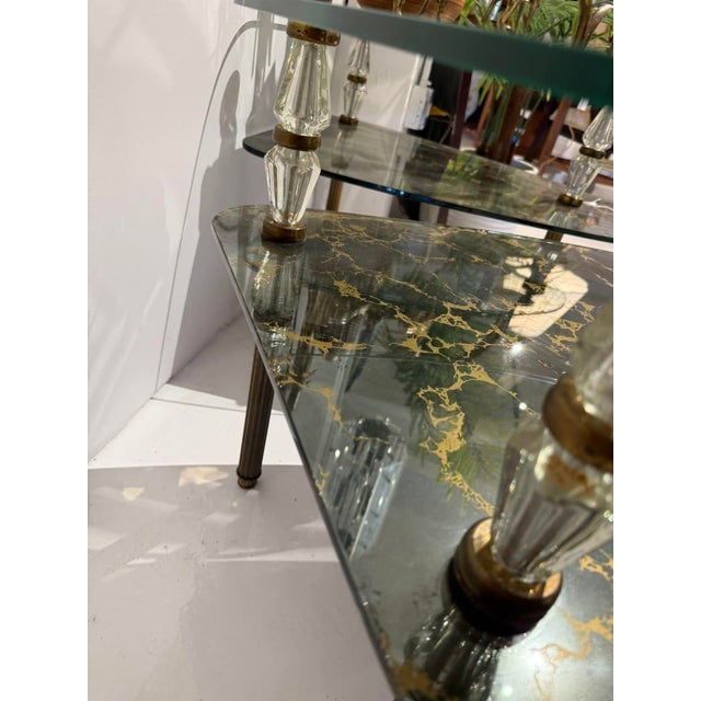 Stunning mid-century Hollywood Regency-style two-tier coffee table featuring ornate faceted crystal/lucite column supports...