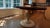 A beautifully crafted round dining table featuring a rich two-tone design that pairs a warm, dark-stained wood top with a...