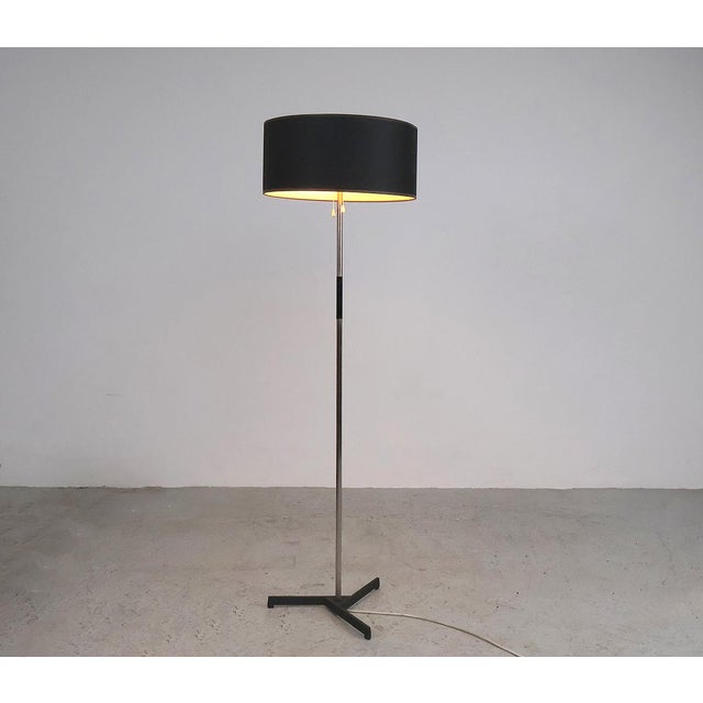 Metal floor lamp, possibly produced in Germany in the 1960s. The lamp is made of metal with a cast iron tripod and a black...