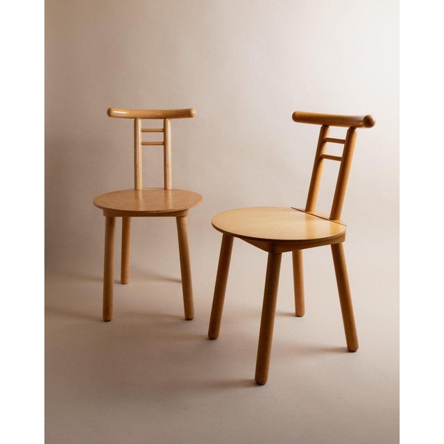 This vintage wooden chair from the 1980s features a minimalist design with light wood and a timeless form, inspired by...