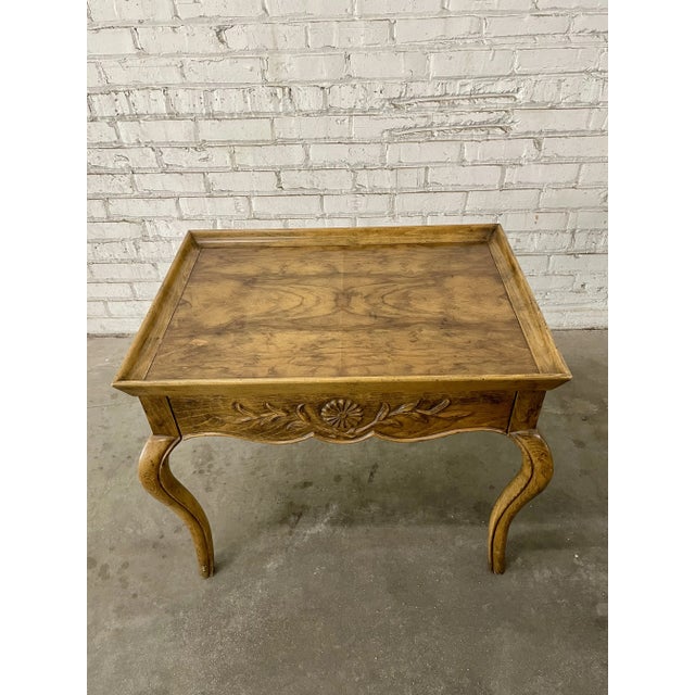 Charming side table in the timeless French Provincial style from Baker. Handmade of walnut with burl walnut veneers, the...