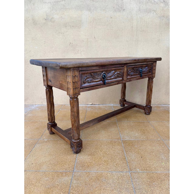 This Spanish low table dates from the 20th century, circa 1930, and is crafted in solid walnut. The piece features a...