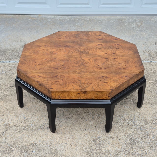 This is a glamorous Asian style octagonal coffee table with a beautifully grained burlwood top and a black lacquered base...