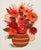 1970's crewel embroidery wall hanging features a vibrant arrangement of warm-toned orange and red yarn flowers in a...