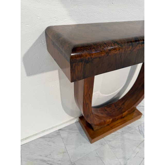 This elegant pair of console tables captures the refined sophistication of Art Deco design. Each table features a striking...