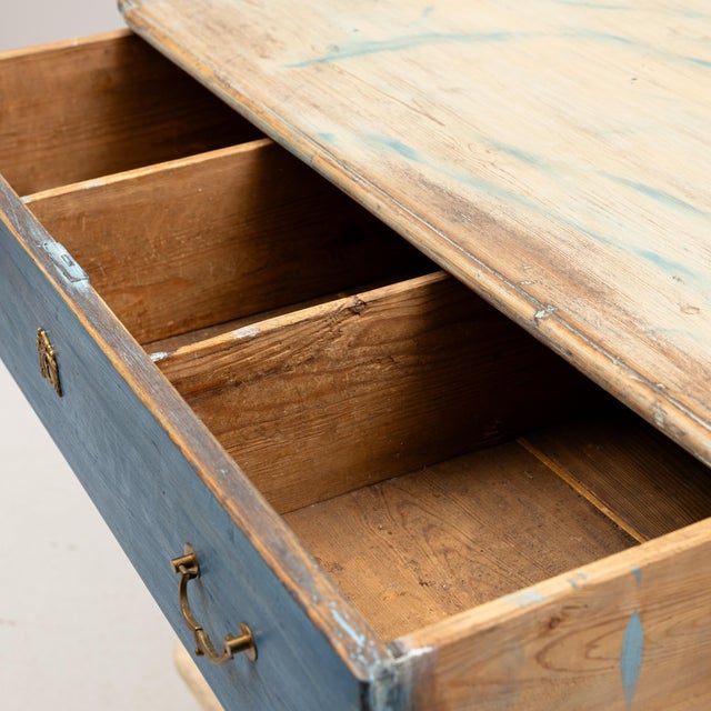 A decoratively framed chest of drawers with rounded corners. The lower section is decorated with arches. The top is...