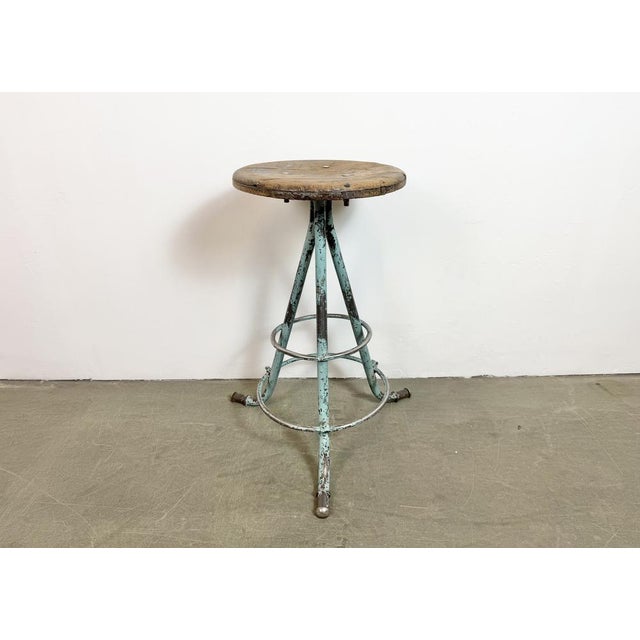 Vintage Industrial factory stool made in former Czechoslovakia during the 1960s It features a wooden seat and a light...