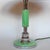 An Art Deco table lamp with domed shade and metal finial. Reeded, mint green bakelite stem over a stepped metal and...