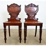 Stunning pair of Regency hall chairs from England. Dramatic in color alone, the solid mahogany planks lend themselves well...