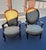 Coordinated pair of Victorian-style parlor armchairs featuring carved wooden frames, curved arms, padded armrests, and...