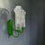 A striking pair of vintage wall sconces featuring vibrant green metal frames and beautifully patterned clear glass shades....