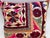 Elegant decorative pillow upholstered in a richly patterned Uzbek textile, featuring charming floral flowerhead motifs and...