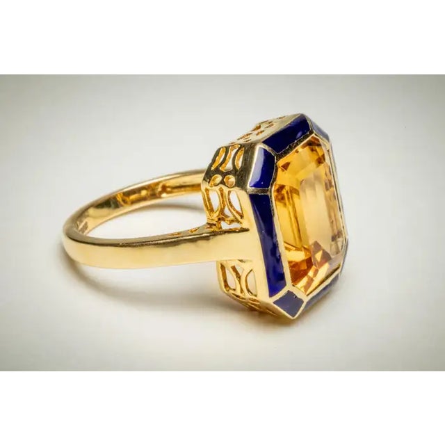 An amazing emerald-cut large citrine gemstone bordered with blue enamel. Set in 18K gold; ring size is 6.25. Carat weight...
