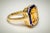 An amazing emerald-cut large citrine gemstone bordered with blue enamel. Set in 18K gold; ring size is 6.25. Carat weight...