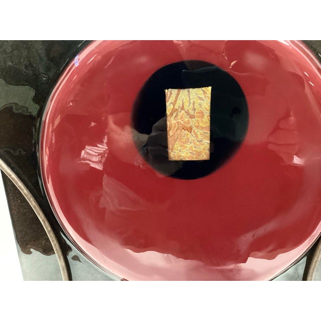 A large, decorative and colorful signed Art Glass Vase in Red and Black glass housed in a custom Industrial style Iron...