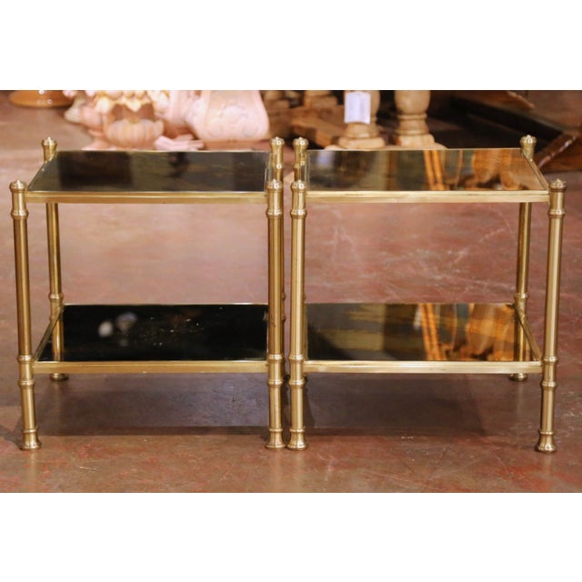 This refined pair of mid-century French side tables was crafted circa 1950 and features an elegant gilt metal frame with...