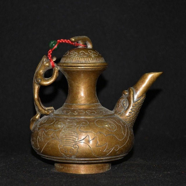 This exquisite vintage Chinese wine pot is crafted from solid bronze, featuring a rich, dark patina that highlights its...