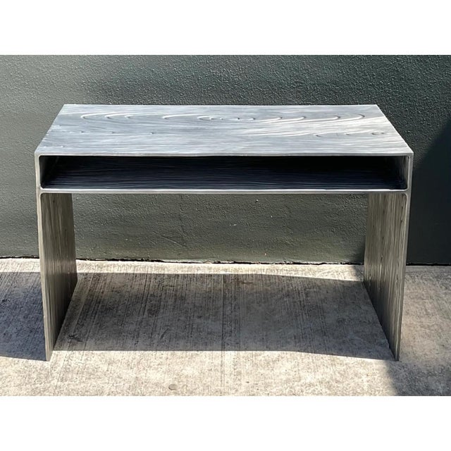 This vintage metal console table embodies a sophisticated modern aesthetic, featuring a remarkable faux wood grain finish...