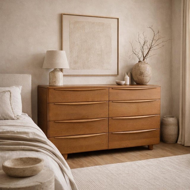 Mid-century modern Heywood-Wakefield lowboy dresser with eight drawers, integrated pulls, and a warm blonde wood finish....