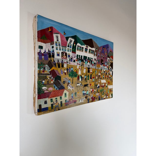 A vibrant 2009 folk art oil on canvas painting by Jadiro, depicting a lively village celebration filled with figures,...