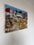 A vibrant 2009 folk art oil on canvas painting by Jadiro, depicting a lively village celebration filled with figures,...