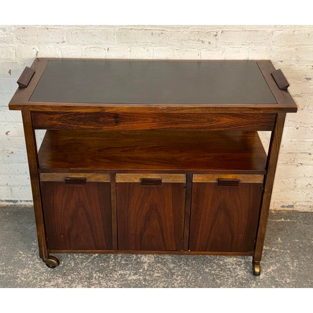 Form meets function in this walnut bar cart. With ample storage space and a sleek black top it's a great addition to any...