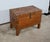 This trunk mounted on four feet, entirely in solid teak, is characterized by its numerous brass brass straps affirming its...