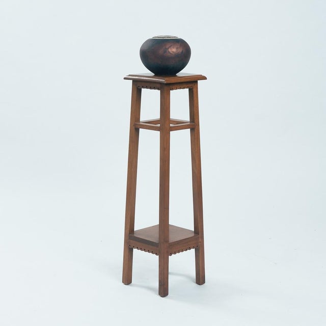 This beautiful wooden plant stand or wooden pedestal. It features a tall, slender frame with four legs that taper...