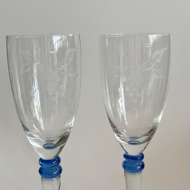 Beautiful pair of vintage champagne flutes that feature delicate etched grape motifs and blue rings at the stem. Very...