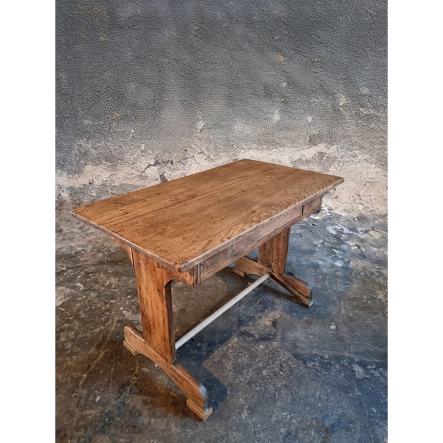 This Antique French Oak Trestle Table dates from the early 1900s and originates from France. Crafted from solid oak, the...
