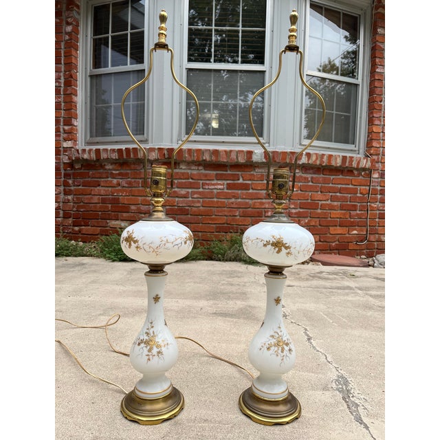 A pair of beautiful porcelain table or buffet lamps with gold leaf painting adorning each. Polished brass accenting...