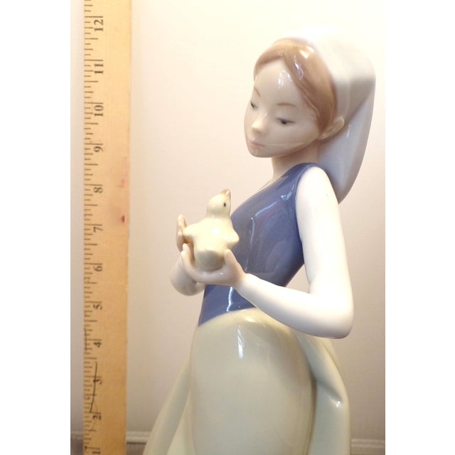 NAO by Lladró “Girl with Bird” Figurine — Model 1204 — 11 Inches — 1994–1995 A serene and beautifully sculpted porcelain...