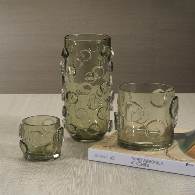 A striking fusion of texture and elegance, the Celeste Tall Glass Vase / Hurricane makes a captivating statement in any...