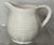 Ceramic pitcher with woven basket motif. Woven basket weave featured on exterior of pitcher including base. Makers mark is...