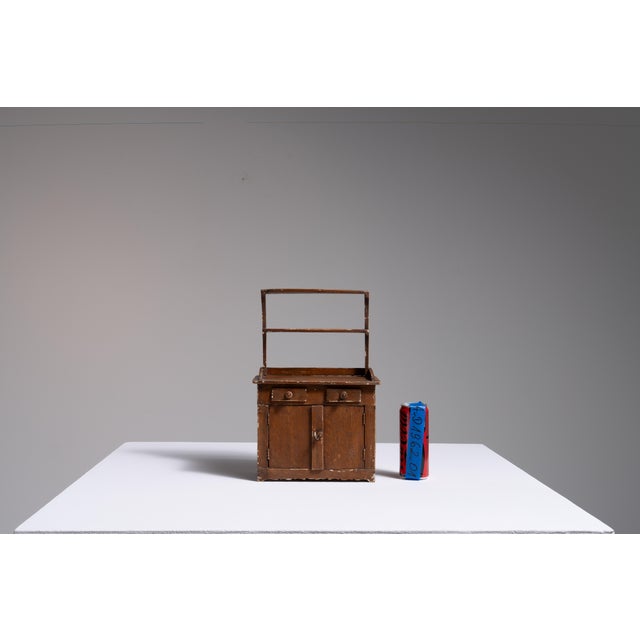 A charming miniature cabinet reflecting the tradition of scaled furniture, often produced for apprenticeships, display...