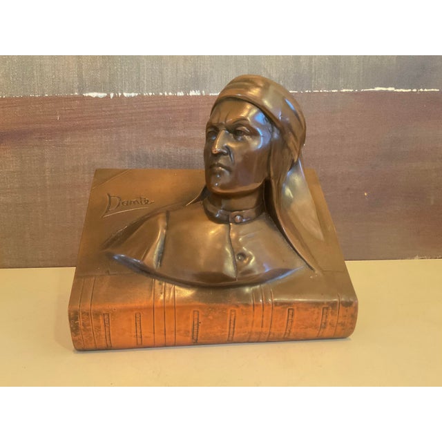 A finely cast bronze sculpture of Dante Alighieri, masterfully integrated into the form of an open book. The bust captures...