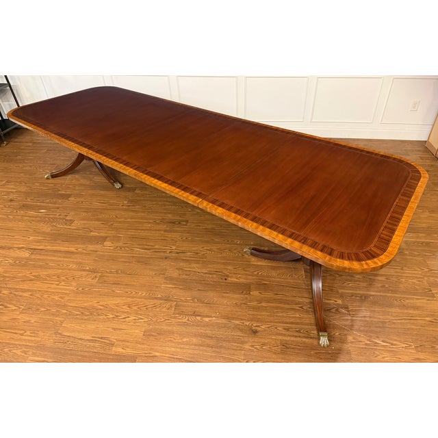 This is a multi-banded mahogany dining table by Leighton Hall. It features a field of cathedral mahogany with exotic...