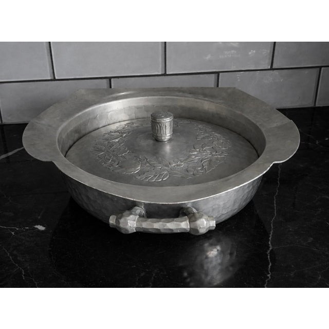 Early 20th century hammered aluminum covered tureen with laurel wreath relief lid and two hand-formed side handles. A...