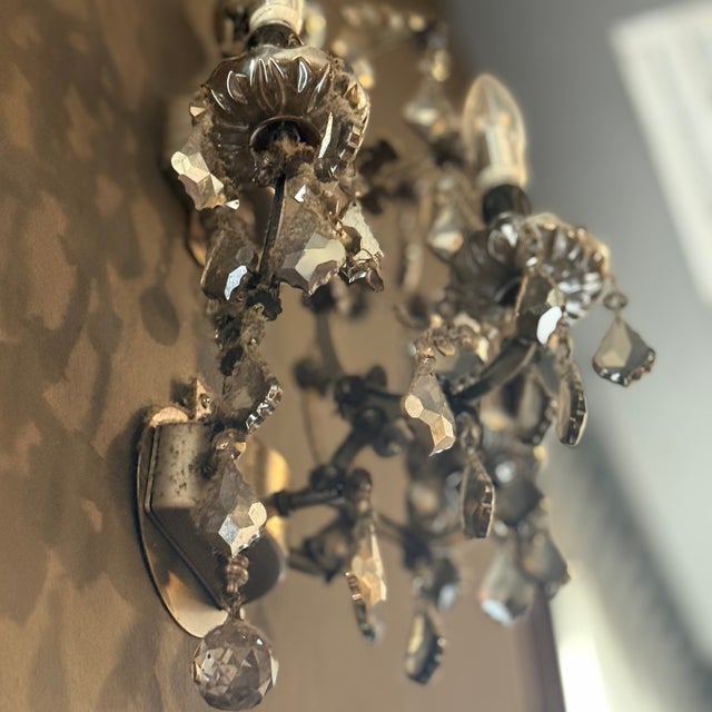 Balanced the opulence of an 18th-century crystal chandelier with a rustic iron frame forged into curving scrollwork. Three...