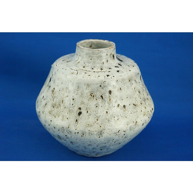 A magnificent ceramic vase, entirely hand-crafted on a lathe, embellished with a rich off-white majolica glaze, created...
