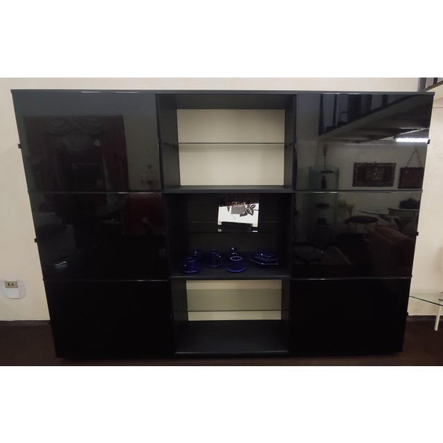 Structure in matt black lacquer, white backs, one of which in black perforated sheet metal for TV compartment, doors in...